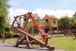 a playground with a slide and a tree house at Przedsiębiorstwo Turystyczne "SOL" in Grzybowo