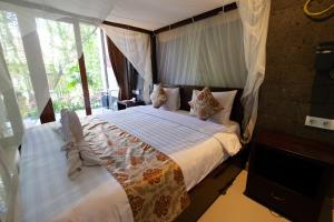 a bedroom with a large bed with a large window at Jiwa's House in Ubud +78 photos