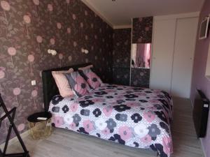 1 dormitorio con 1 cama y papel pintado con motivos florales en 19 Rue du Cadran, en Montmorillon