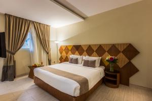 a hotel room with a bed and a vase of flowers at Al Muhaidb Al Diwan - Al Olaya - Economic in Riyadh +15 photos