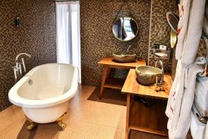 La salle de bains est pourvue d'une baignoire, d'un lavabo et d'un miroir. dans l'établissement Le Temple De Jeanne, à Paris