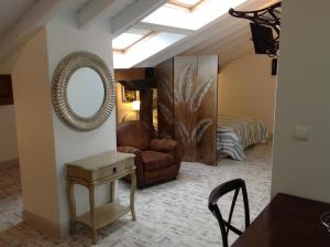 a living room with a mirror and a chair at Apartamentos Rurales La Villa de Piedra in Cartes