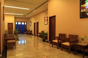 a waiting room with wooden chairs and tables at Omah Qu Guesthouse Malioboro in Yogyakarta