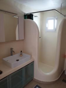 a bathroom with a white sink and a mirror at Maya Apartments in Dexamenes