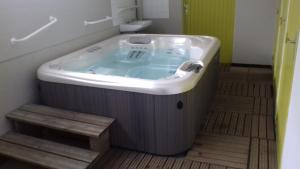 a large bath tub in a bathroom with a wooden floor at Camping de Kergo in Ploemel