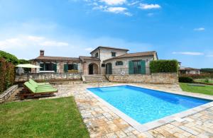 une maison avec une piscine dans la cour dans l'établissement Villas Barat by Istarski Dvori, à Višnjan