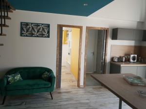 a living room with a green couch and a table at APPART HOTEL LA CENSE PIERROT DES PRINCES in Saint-Amand-les-Eaux