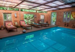 a large swimming pool with chairs and a table at Estalagem Wiesbaden in Monte Verde