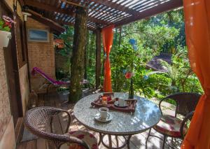 a patio with a table and chairs on a deck at Estalagem Wiesbaden in Monte Verde
