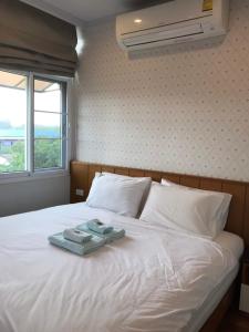 ein Bett mit zwei Handtüchern darüber in der Unterkunft KM Condo in Langu