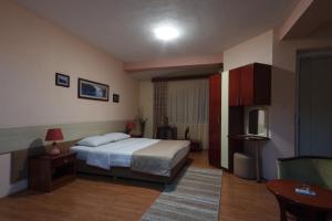 1 dormitorio con cama, mesa y TV en Hotel Ilinden, en Strumica