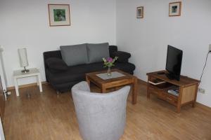 a living room with a couch and a table with a tv at Ferienwohnung Sannhoff in Schneverdingen +5 photos