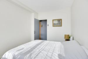 a white bedroom with a large white bed at Charming apartment with terrace by Weekome in Paris