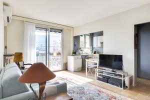 een woonkamer met een bank en een televisie bij Charming apartment with terrace by Weekome in Parijs