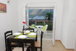 a dining room with a table and chairs and a window at Hera Apartment in Donji Stoliv