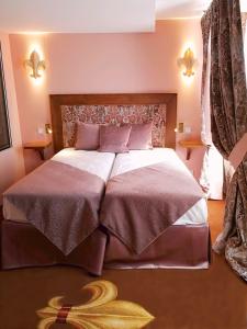 a bedroom with a large bed with two pillows at Le Temple De Jeanne in Paris