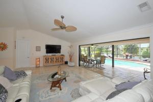a living room with a white couch and a tv at Villa Endless Love in Cape Coral