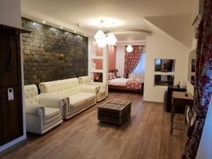 a living room with white furniture and a brick wall at Studio B in Buftea +30 photos