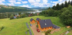 an aerial view of a house on a hill next to a river at Domki Złota Rybka nad Jeziorem- Jacuzzi in Zawóz