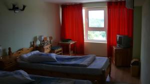 a bedroom with two beds and a window with red curtains at Villa Climate Guest House in Varna City