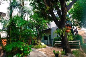 a garden with a bench and trees and a building at Bed garden 26 in Bangkok