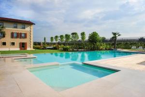 a large swimming pool with blue water in a yard at Antica Corte la Valle in Sona