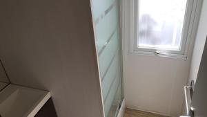 a white bathroom with a window and a sink at Camping la Croix du Sud in Saint-Tropez