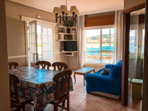 a living room with a table and a blue couch at Apartamentos Playa Areas in Sanxenxo