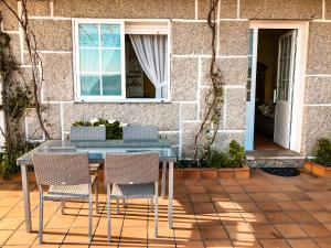 uma mesa e cadeiras em frente a uma casa em Apartamentos Playa Areas em Sanxenxo