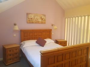 1 dormitorio con 1 cama, 2 mesitas de noche y ventana en The Gardeners Country Inn, en Hull