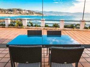 uma mesa e cadeiras com vista para o oceano em Apartamentos Playa Areas em Sanxenxo