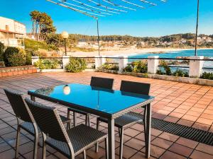 a table and chairs on a patio with a view of the beach at Apartamentos Playa Areas in Sanxenxo