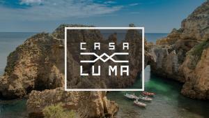un grupo de barcos en el agua cerca de un acantilado en Casa Luma B&B, en Lagos