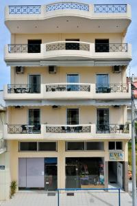 un edificio de apartamentos con balcones y mesas en Evia Studios, en Loutra Edipsou