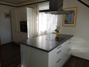 eine Küche mit einer schwarzen Arbeitsplatte und einem Fenster in der Unterkunft Vronis-Apartment in Stephanshart
