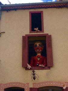 une statue d'un garçon avec un visage clown accroché à une fenêtre dans l'établissement Bois Mort farm, à Gourgé