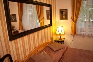 1 dormitorio con cama y espejo en la pared en Da Vinci Apartment, en Cracovia