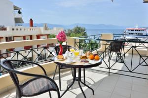 a table with food on a balcony with a cruise ship at Evia Studios in Loutra Edipsou