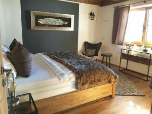 a bedroom with a bed with a comforter and a desk at CHALET BELLE KAISER by Belle Stay in Going