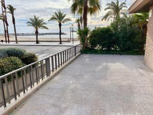 a walkway next to a beach with palm trees at APARTAMENTO - WIFI FREE - FRENTE AL MAR in Salou