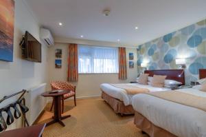 Кровать или кровати в номере Langstone Cliff Hotel