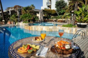 a table with food and drinks next to a swimming pool at Mare Hotel in Savona