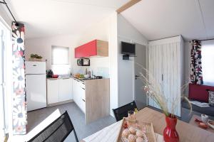 a kitchen with a table and a kitchen with a kitchen at Camping de Kergo in Ploemel