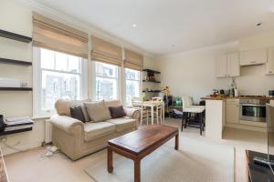 a living room with a couch and a table at 1-bed flat at the heart of Fulham & Parsons Green! in London