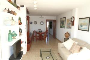 een woonkamer met een bank en een tv bij Apartamento Bahia Dorada in Cambrils