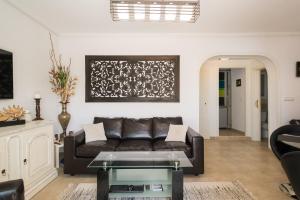 a living room with a leather couch and a table at Beach House - healthy, protected location! El Campello, Alicante Spain in El Campello