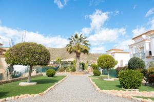 a house with a gravel driveway and trees at Beach House - healthy, protected location! El Campello, Alicante Spain in El Campello