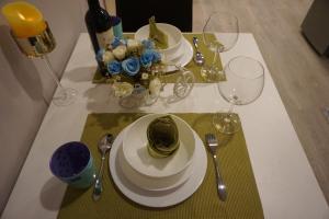 un tavolo con due piatti e bicchieri da vino sopra di MAYA宁曼路 Plam phoenix 高级公寓 a Chiang Mai