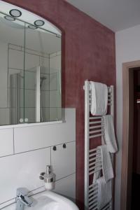 a bathroom with a sink and a mirror and towels at Alter Fritz Erfurt in Erfurt