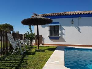 krzesło i parasol przy basenie w obiekcie LA CHANCA RURAL w mieście Chiclana de la Frontera